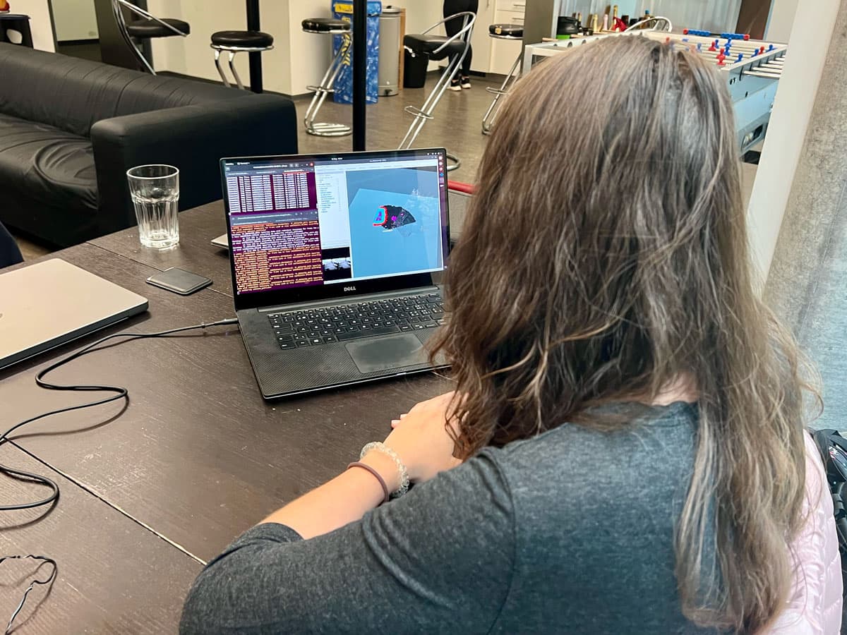 Victoria at her laptop, with the screen showing the depth camera's input and the navigation path being generated.